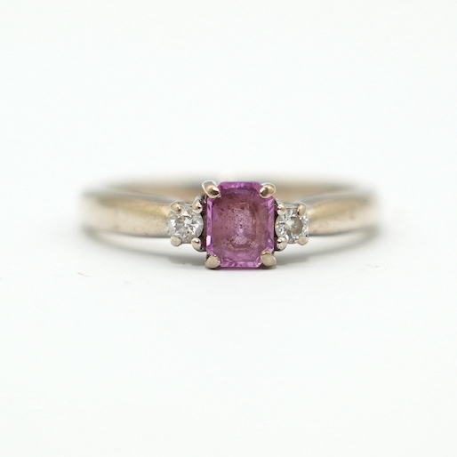 A modern 18ct white gold, single stone pink sapphire and two stone diamond set ring, size J, gross weight 3.7 gram. Condition - good